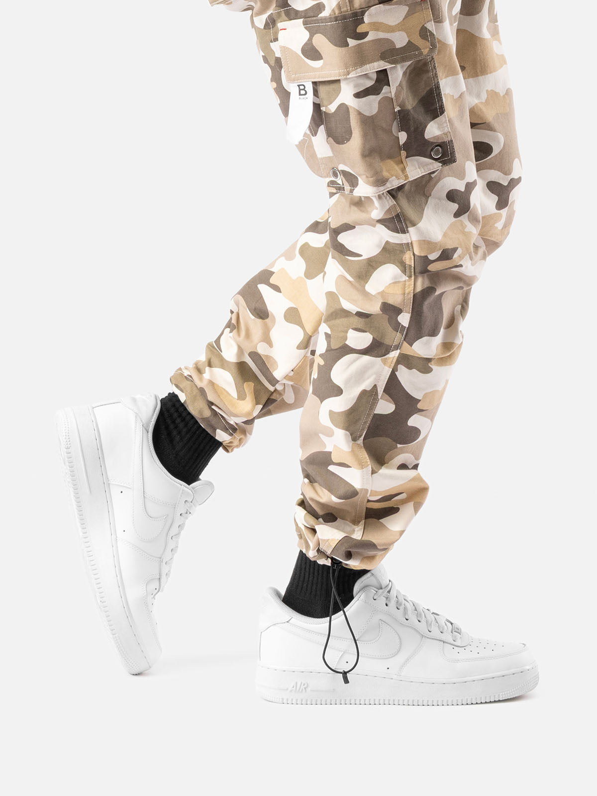 Close-up of ankle drawstrings of sand camo cargo pants with side pockets and simple back pockets.