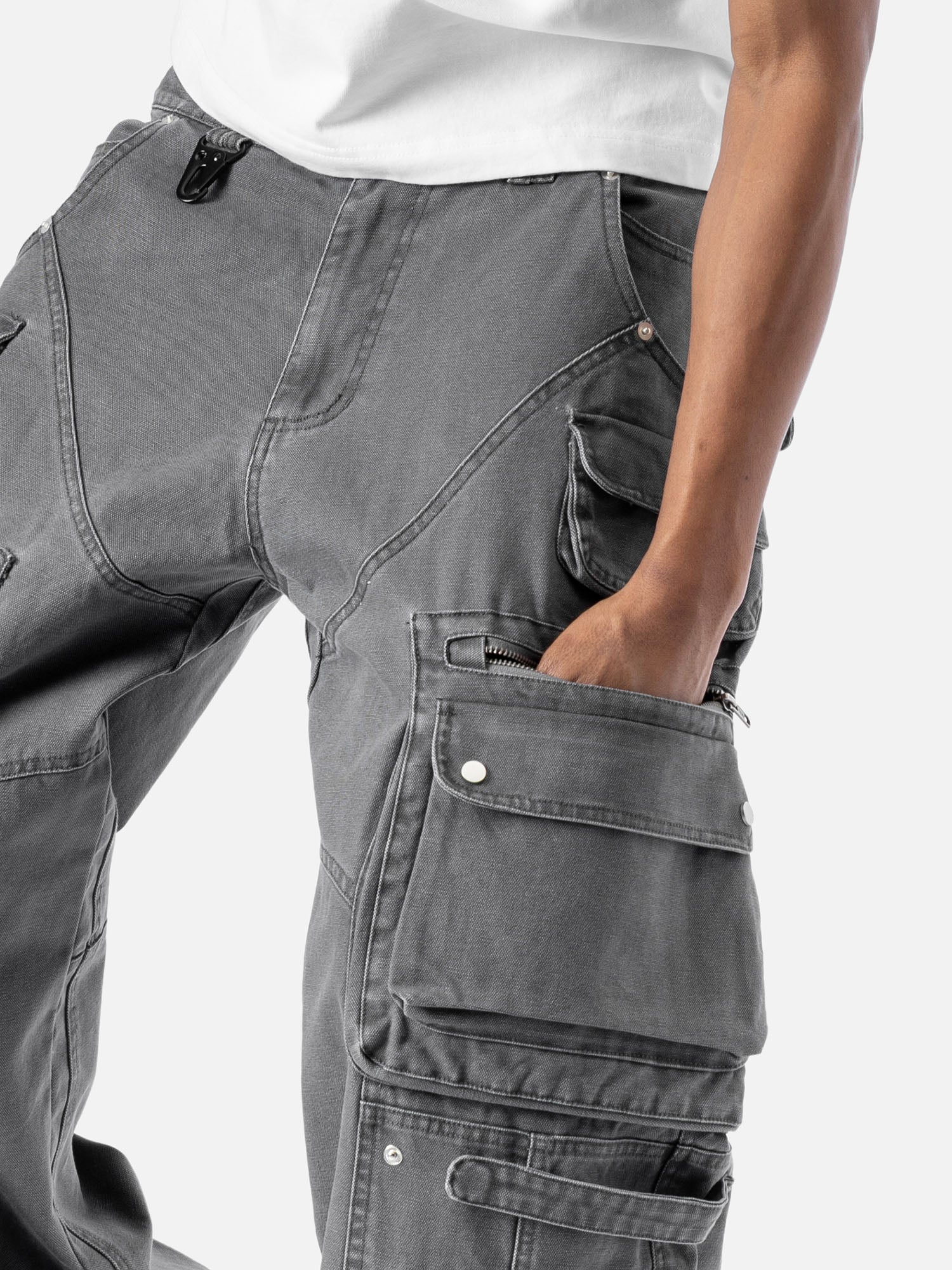 Close-up of a side pocket of grey cargo pants with multiple functional pockets and a zipper detail.